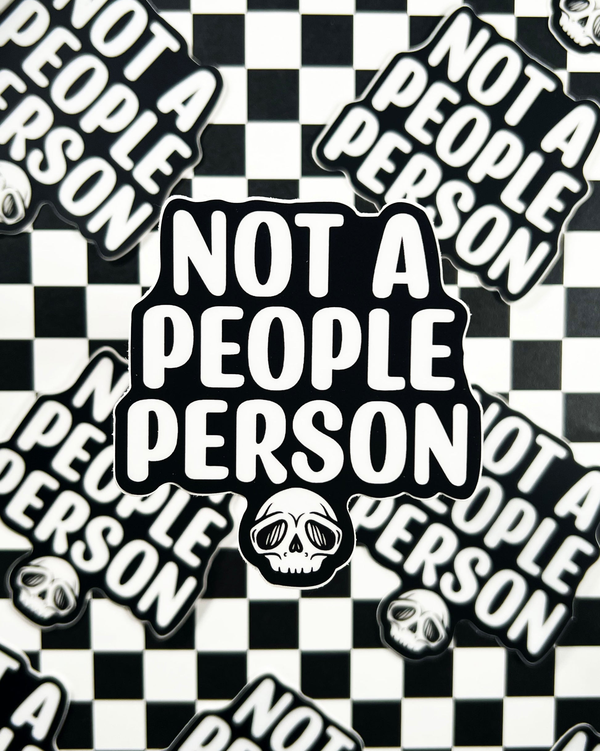 Stickers with 'Not a People Person' text and skull designs on a checkered background