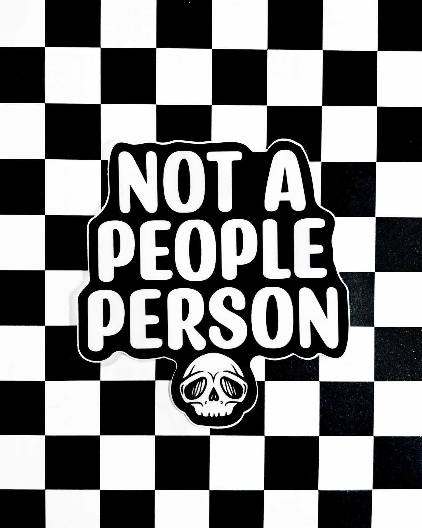 Sticker with 'Not a People Person' text on a black and white checkered background