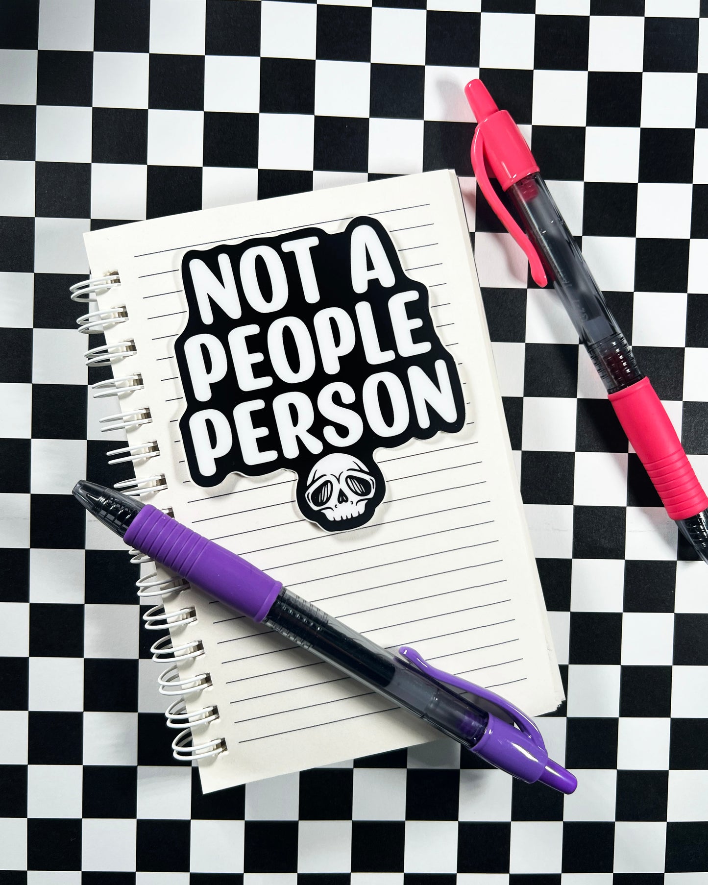 Notebook with 'Not a People Person' sticker on a checkered background