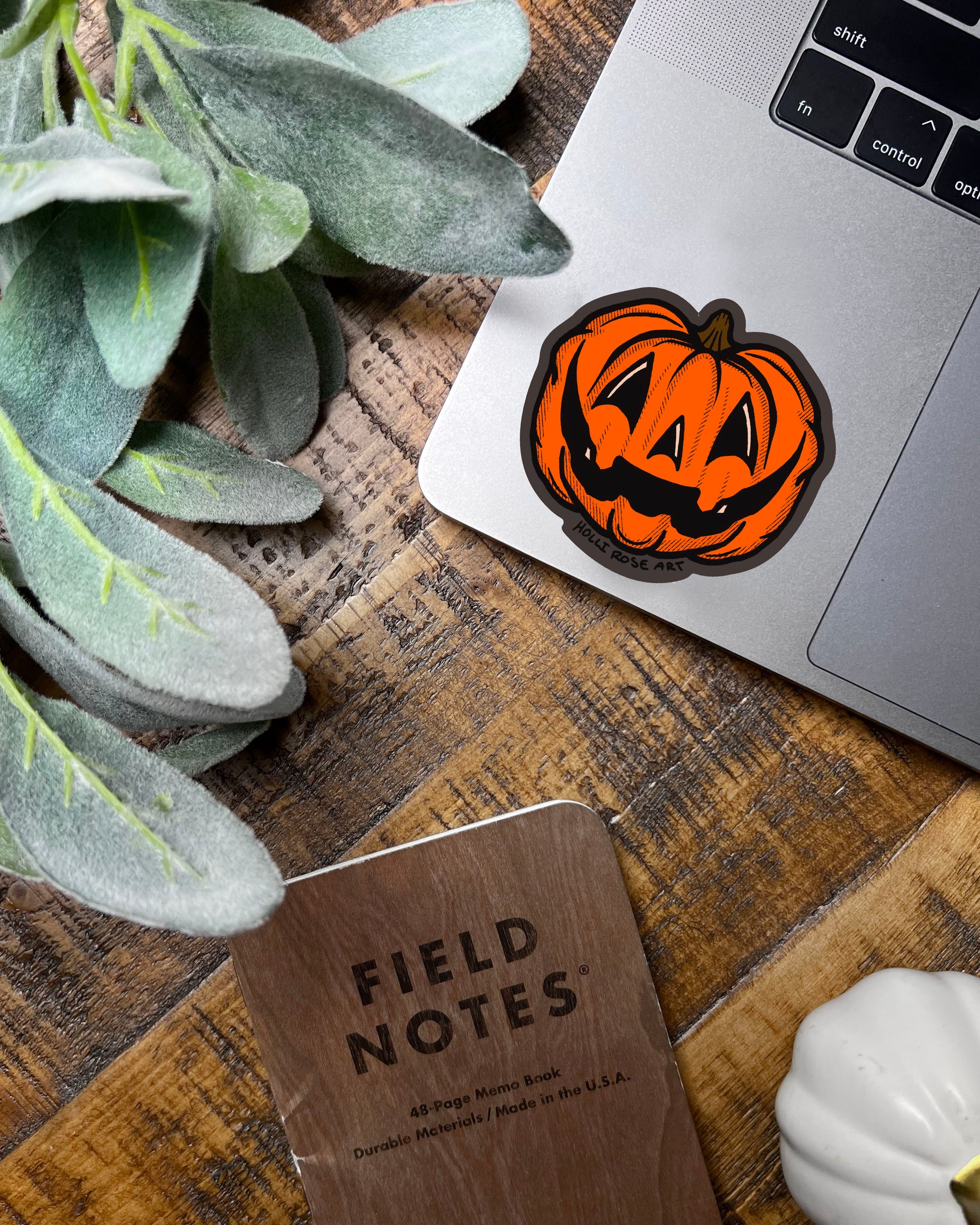 orange jack o lantern pumpkin sticker on a laptop