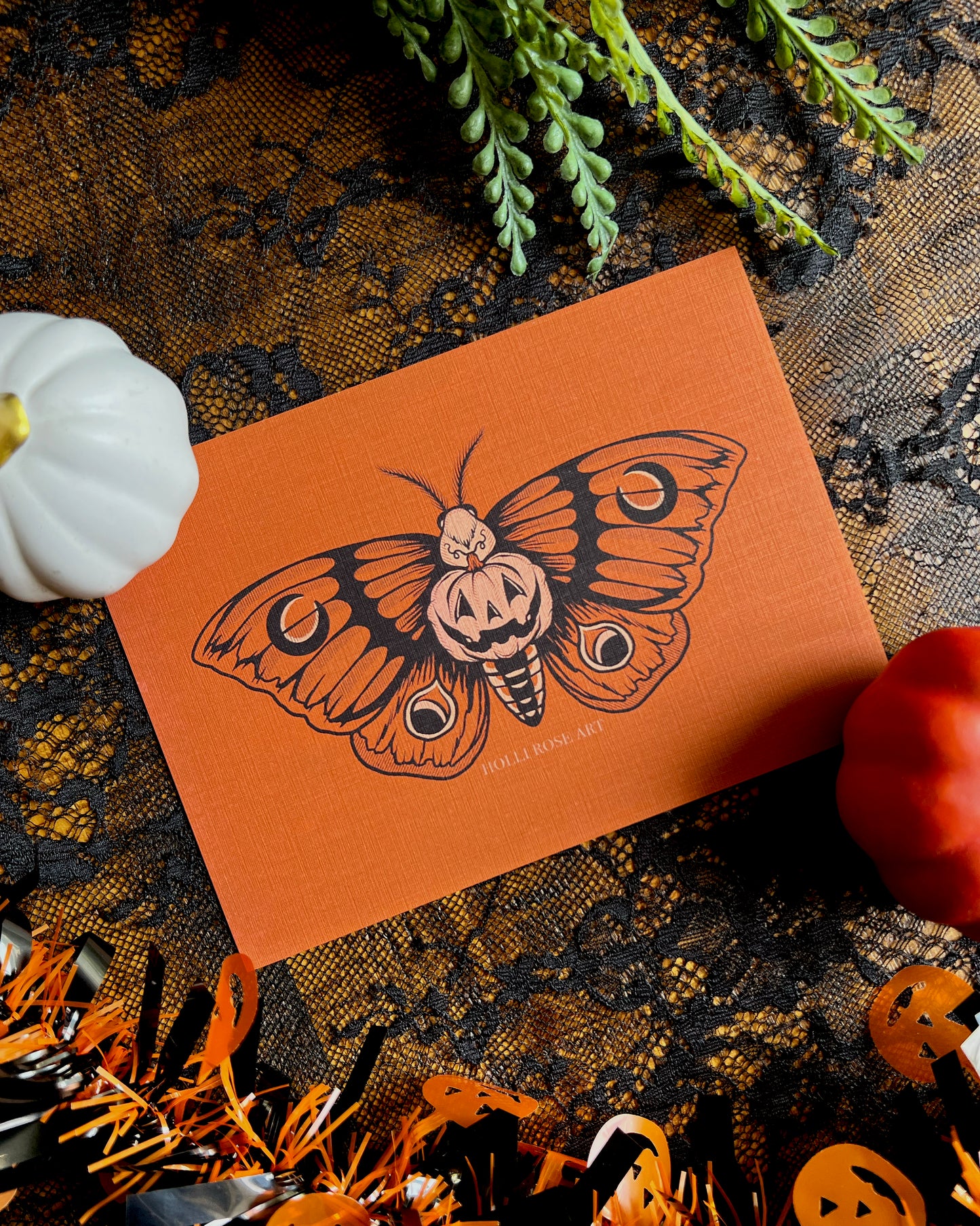 a print with a moth and a pumpkin in the middle of its body smiling
