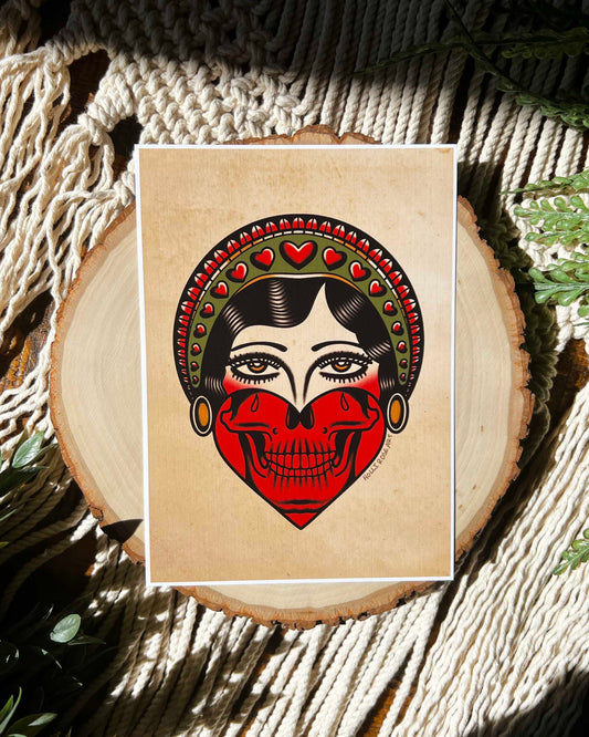 print of an American traditional girl face on the top and a skull jaw in a hard at the bottom