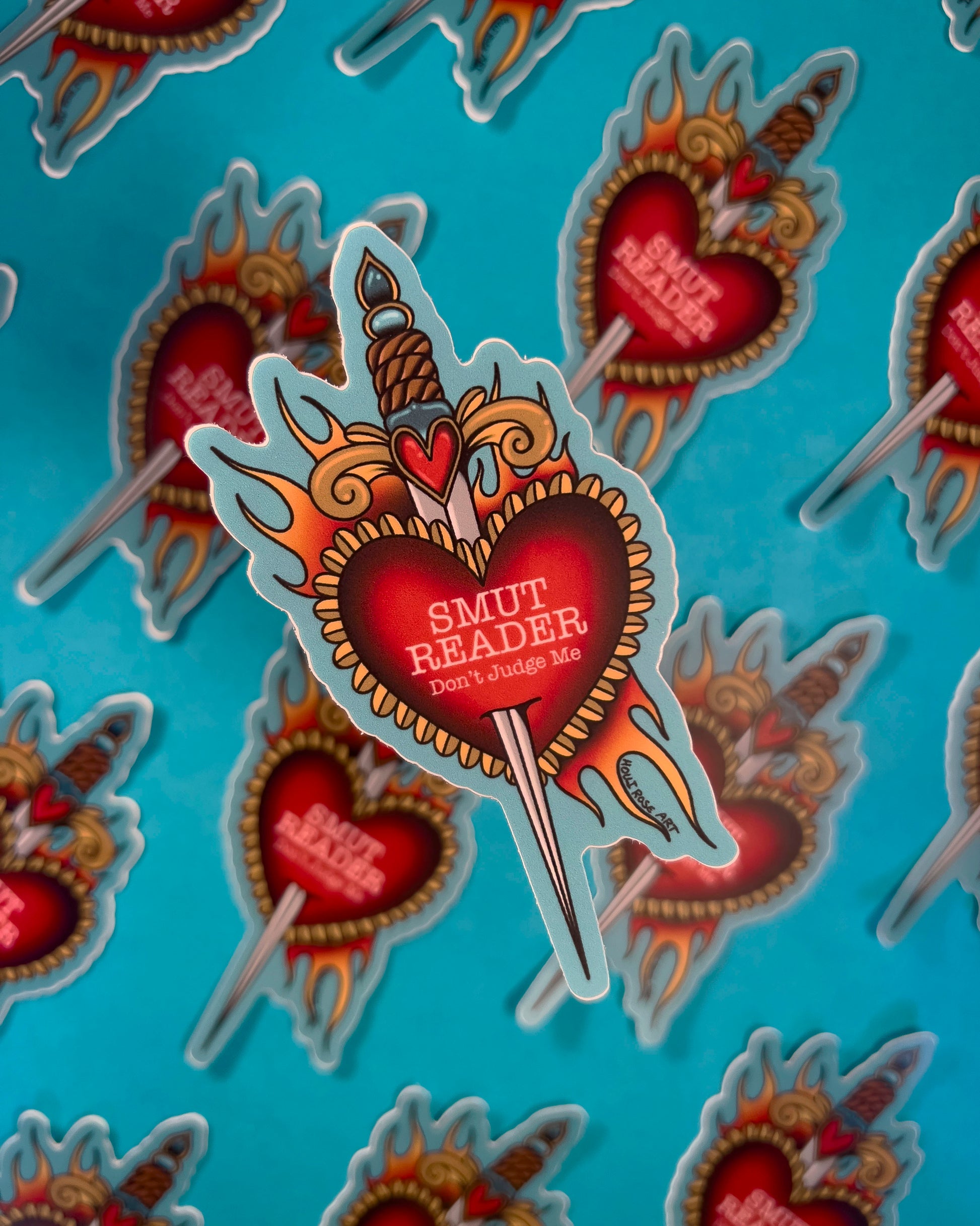 a sticker saying smut with a heart and a dagger 