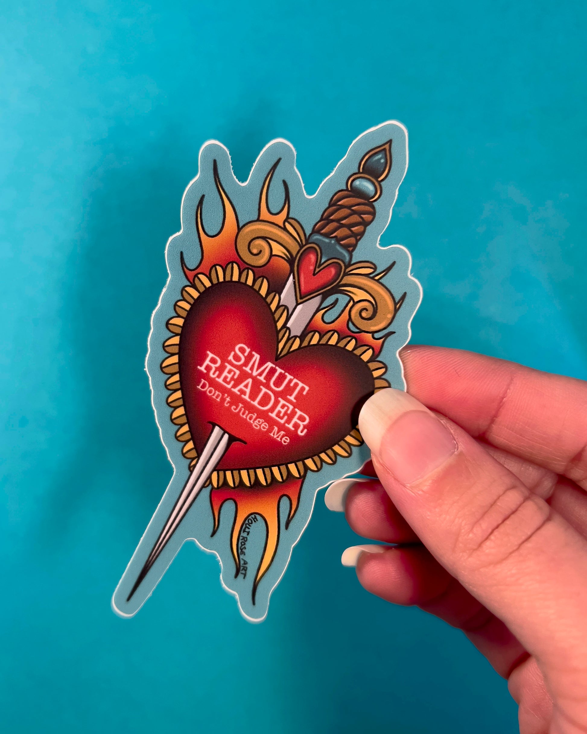 a sticker saying smut with a heart and a dagger 