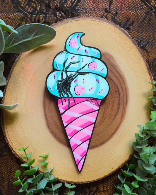 Colorful ice cream cone with a spider design on a wooden background