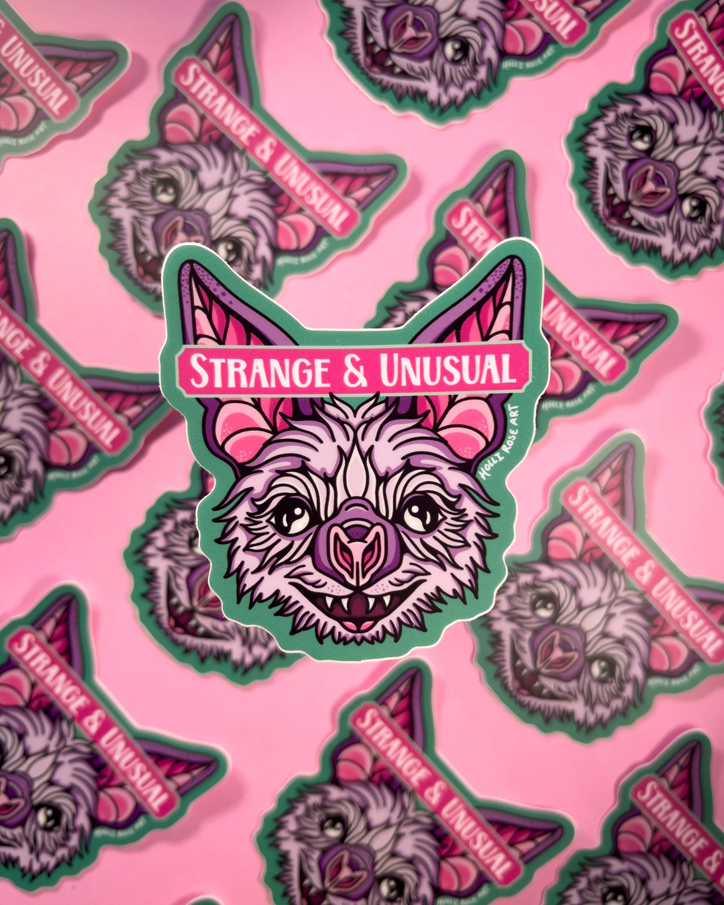 sticker with a bat head and the phrase "strange and unusual"