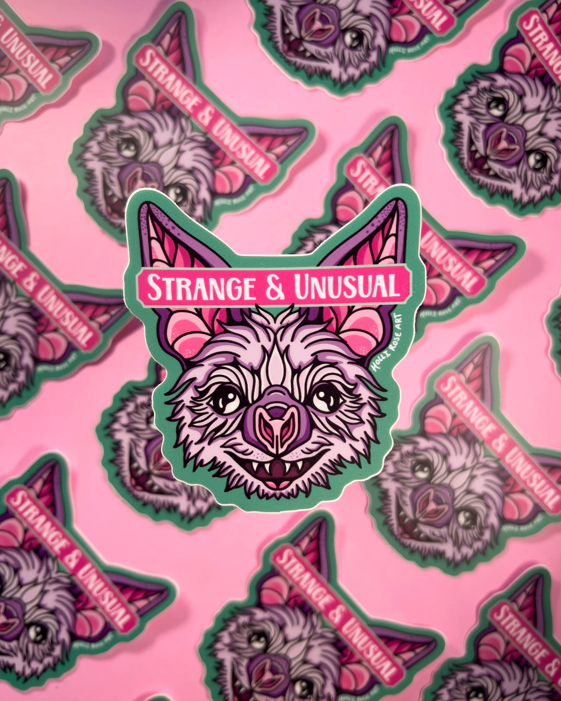sticker with a bat head and the phrase "strange and unusual"