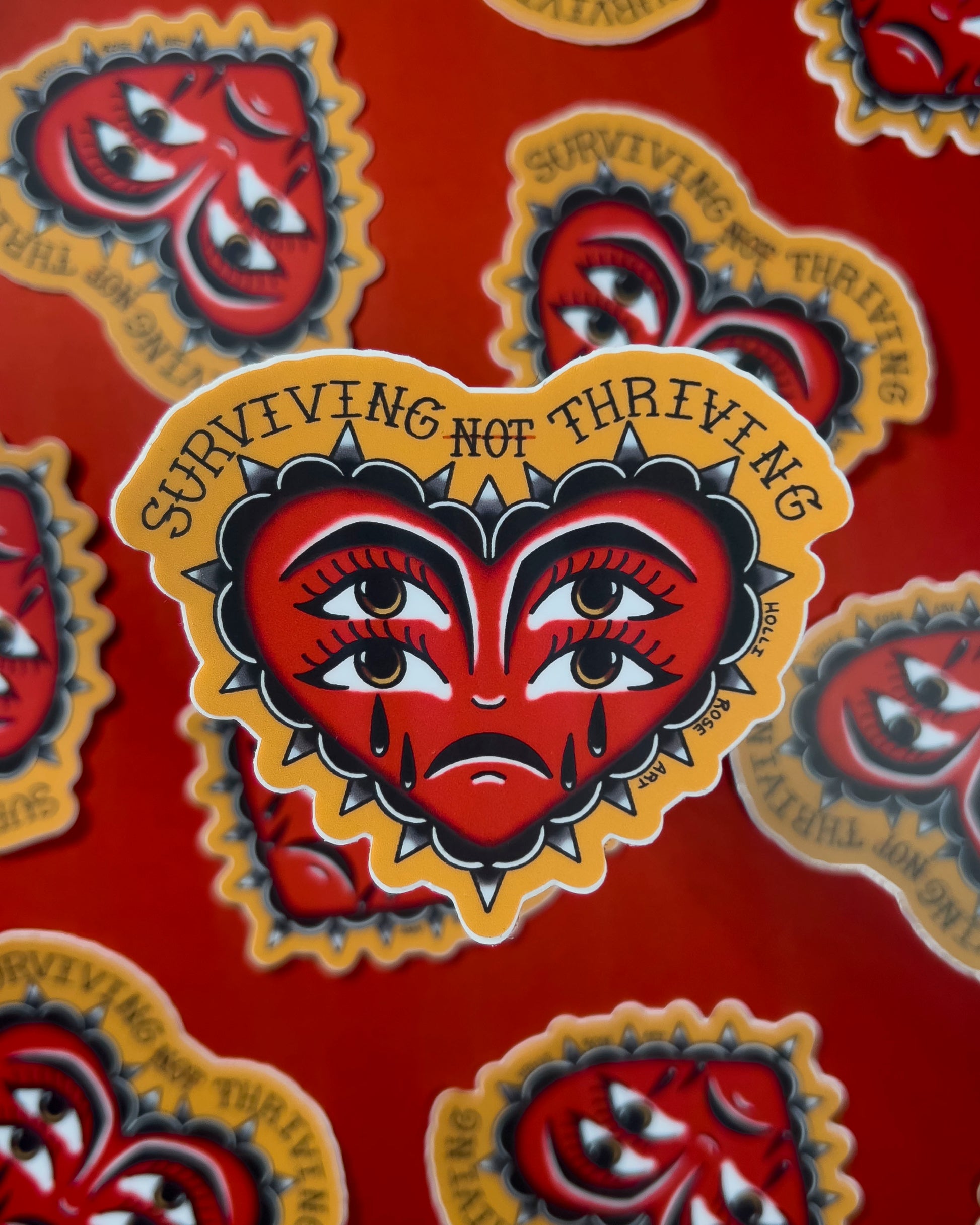 heart sticker with eyes that says "surviving not thriving"