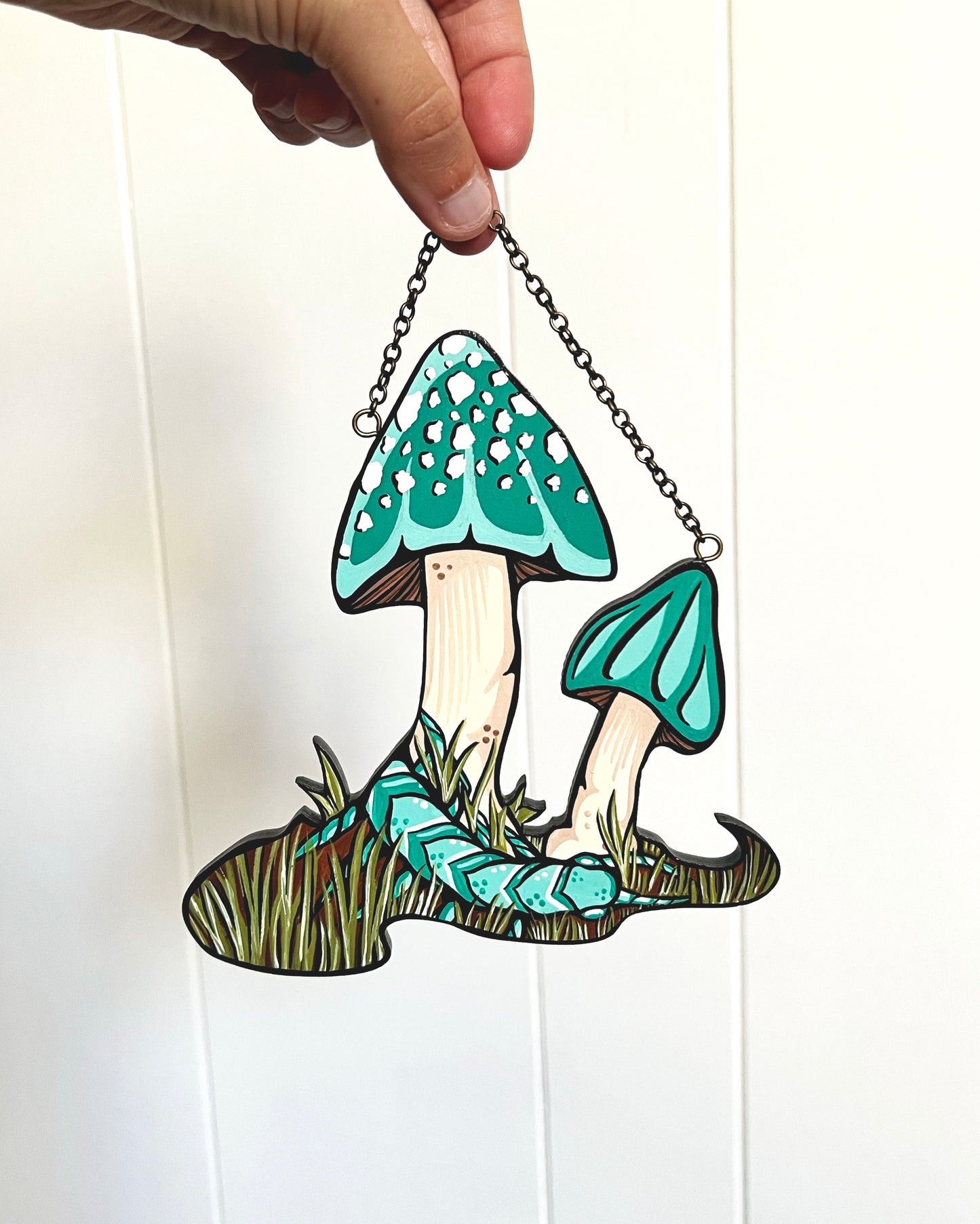 hand painted hanging of teal mushrooms and a teal centipede