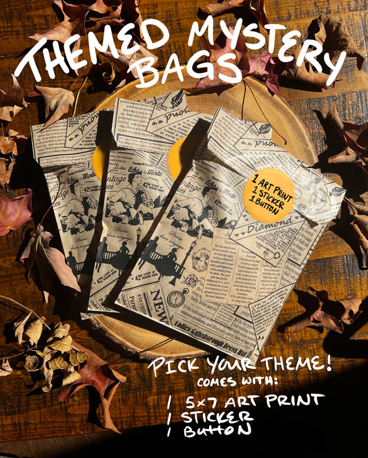 Three themed mystery bags with a vintage newspaper print design, displayed on a wooden surface surrounded by autumn leaves. The bags are marked with tags indicating they come with an art print, sticker, and button.