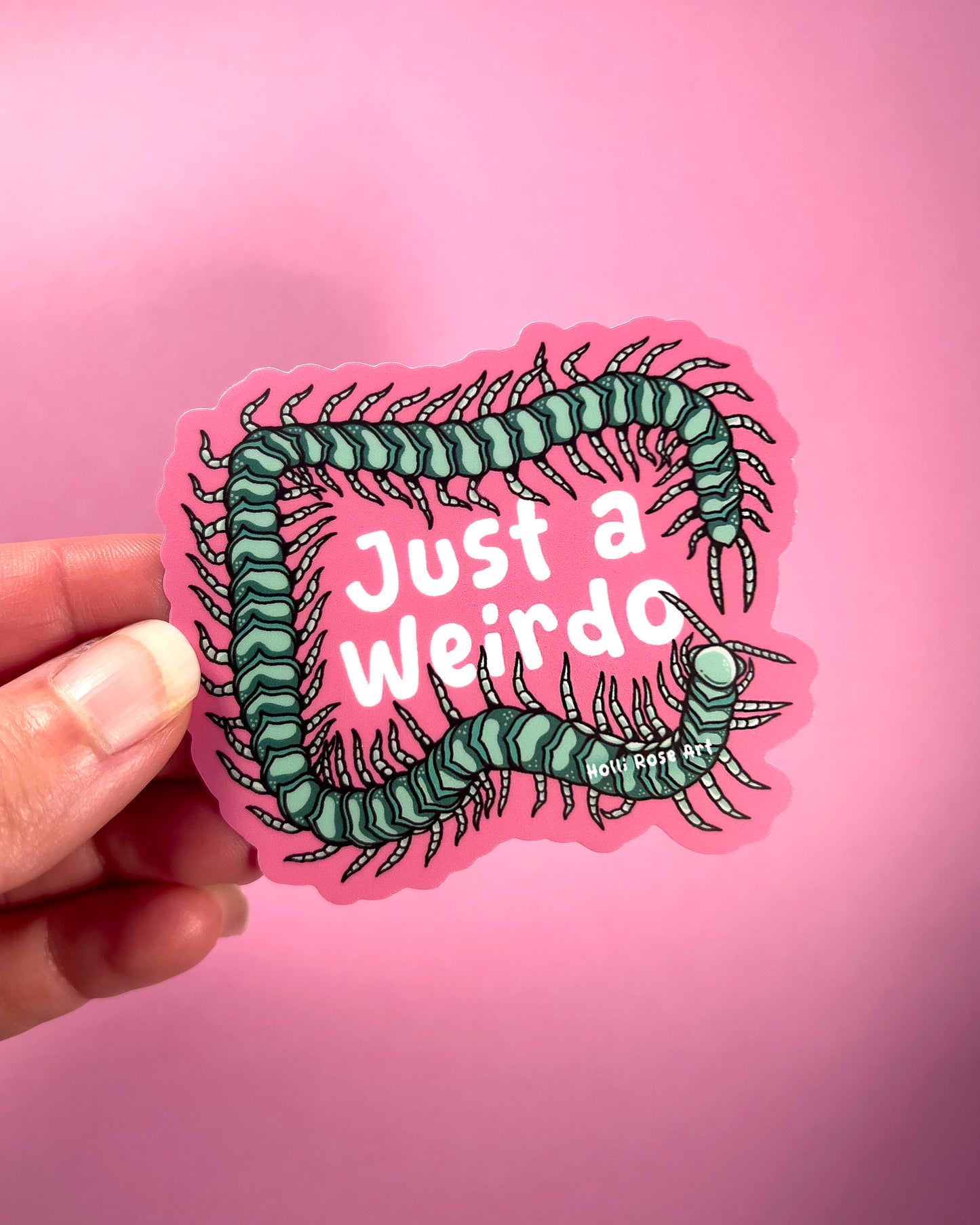 Sticker with centipede design and 'Just a Weirdo' text on pink background