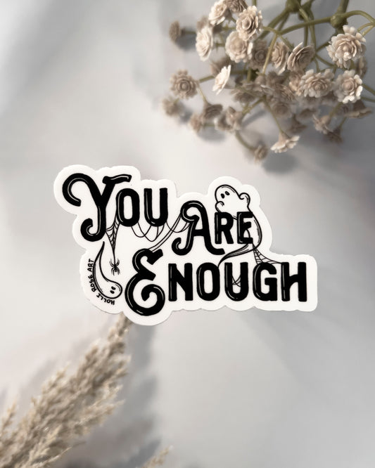 a sticker saying you are enough with ghosts